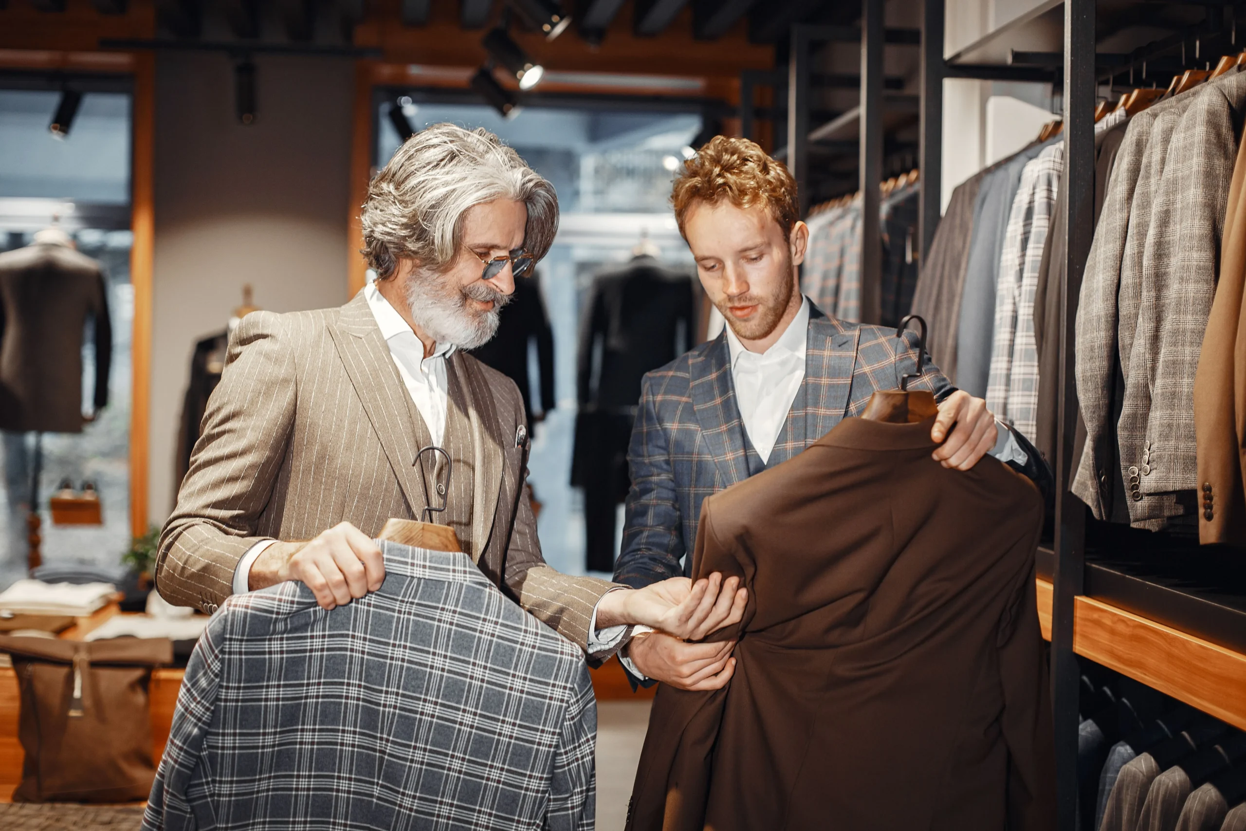 Image of a professional tailor showing a client different suit options
